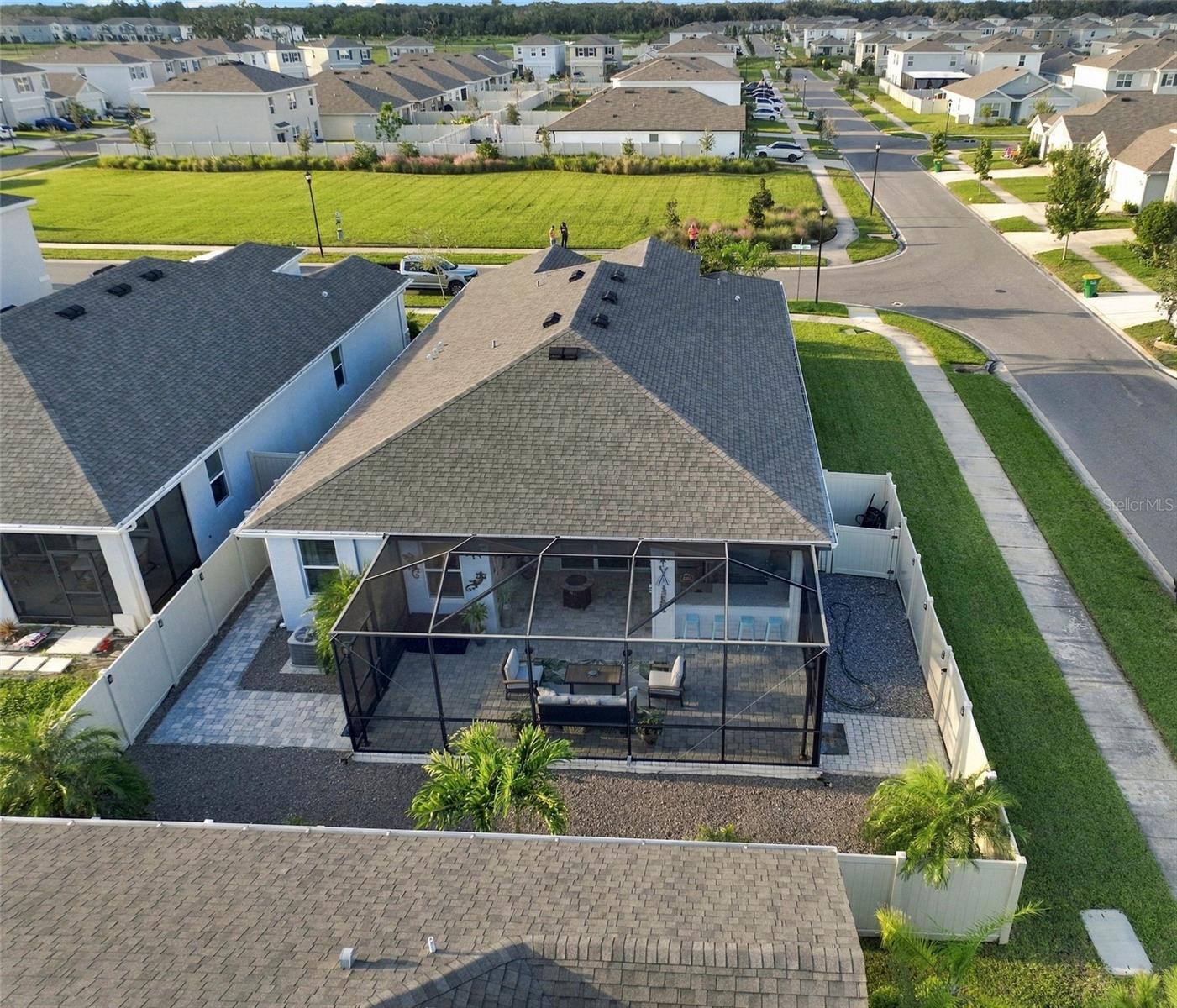 Rear View Showcasing the Home's Roofline and Outdoor Living Area Rear View Showcasing the Home's Roofline and Outdoor Living Area