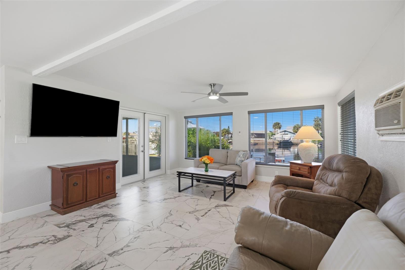 Water view from Family Room - access to the screened FL room with adjustable shades.