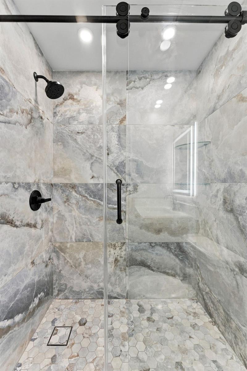 Beautifully designed hall shower with sleek glass bypass doors and modern finishes