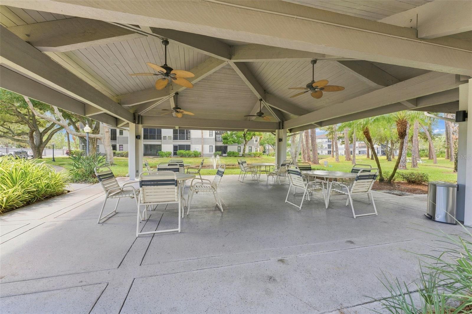Covered poolside seating overlooking the peaceful community pond