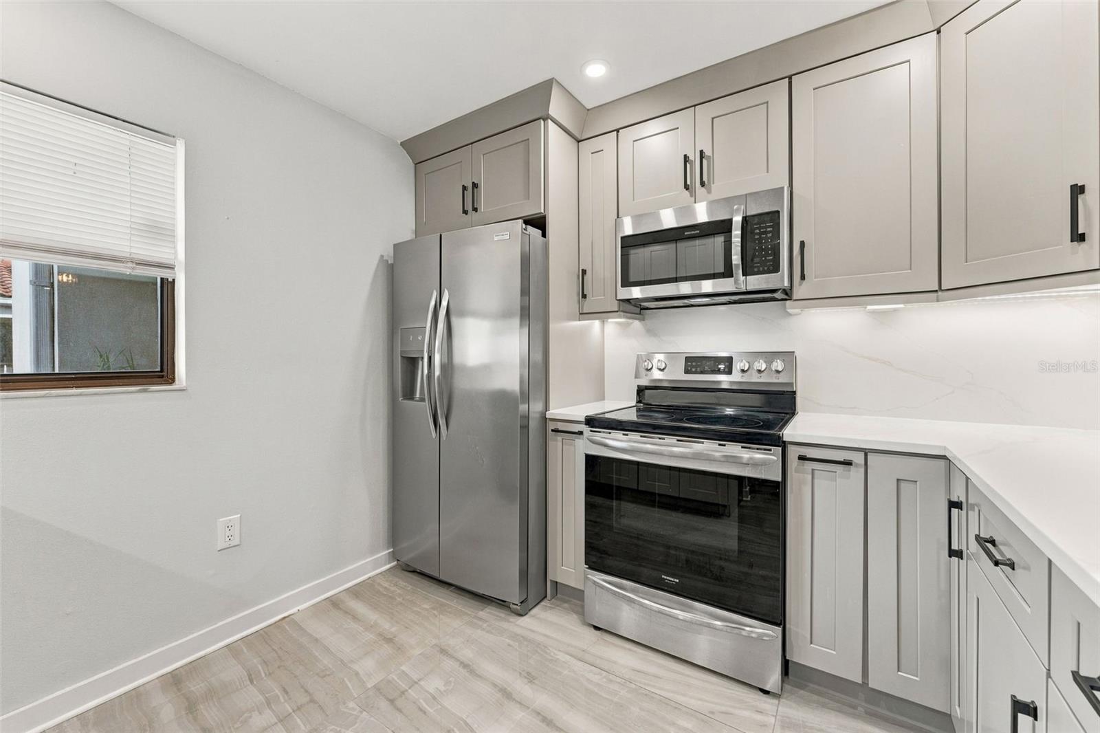 Updated kitchen with shaker-style cabinetry and new appliances