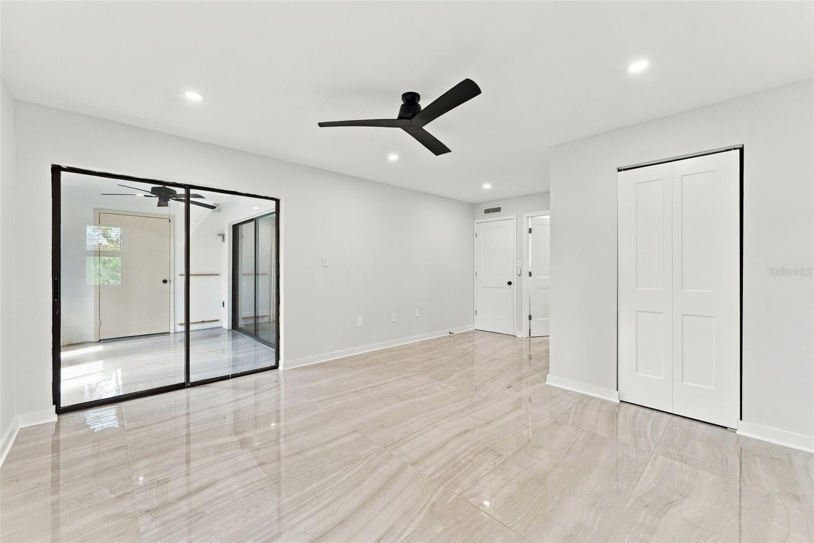 Primary bedroom with sliding glass doors opening to the patio
