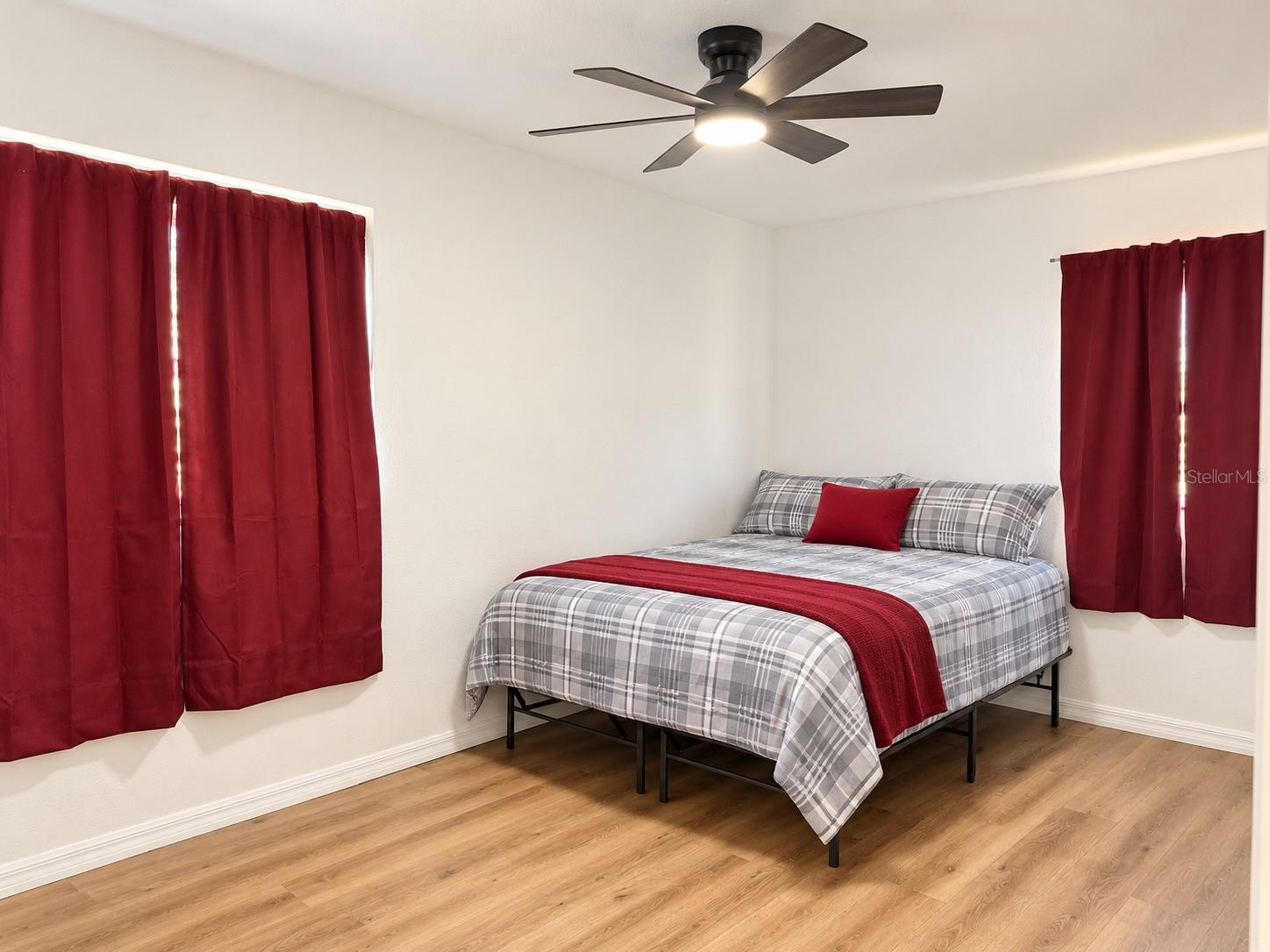 Primary Spacious bedroom featuring neutral walls, updated flooring, ceiling fan, and natural light.