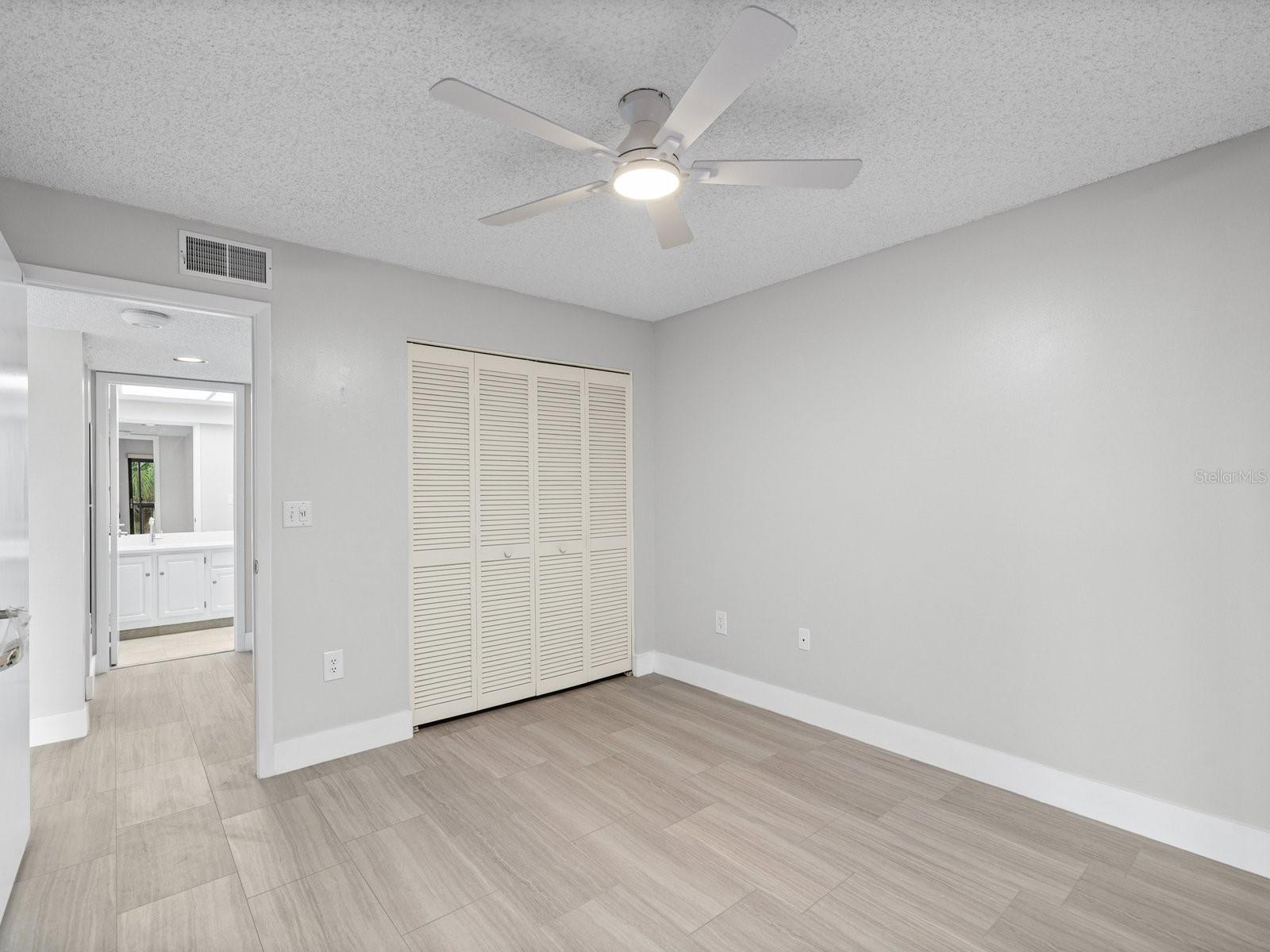 Guest bedroom with hall to guest bath and laundry room