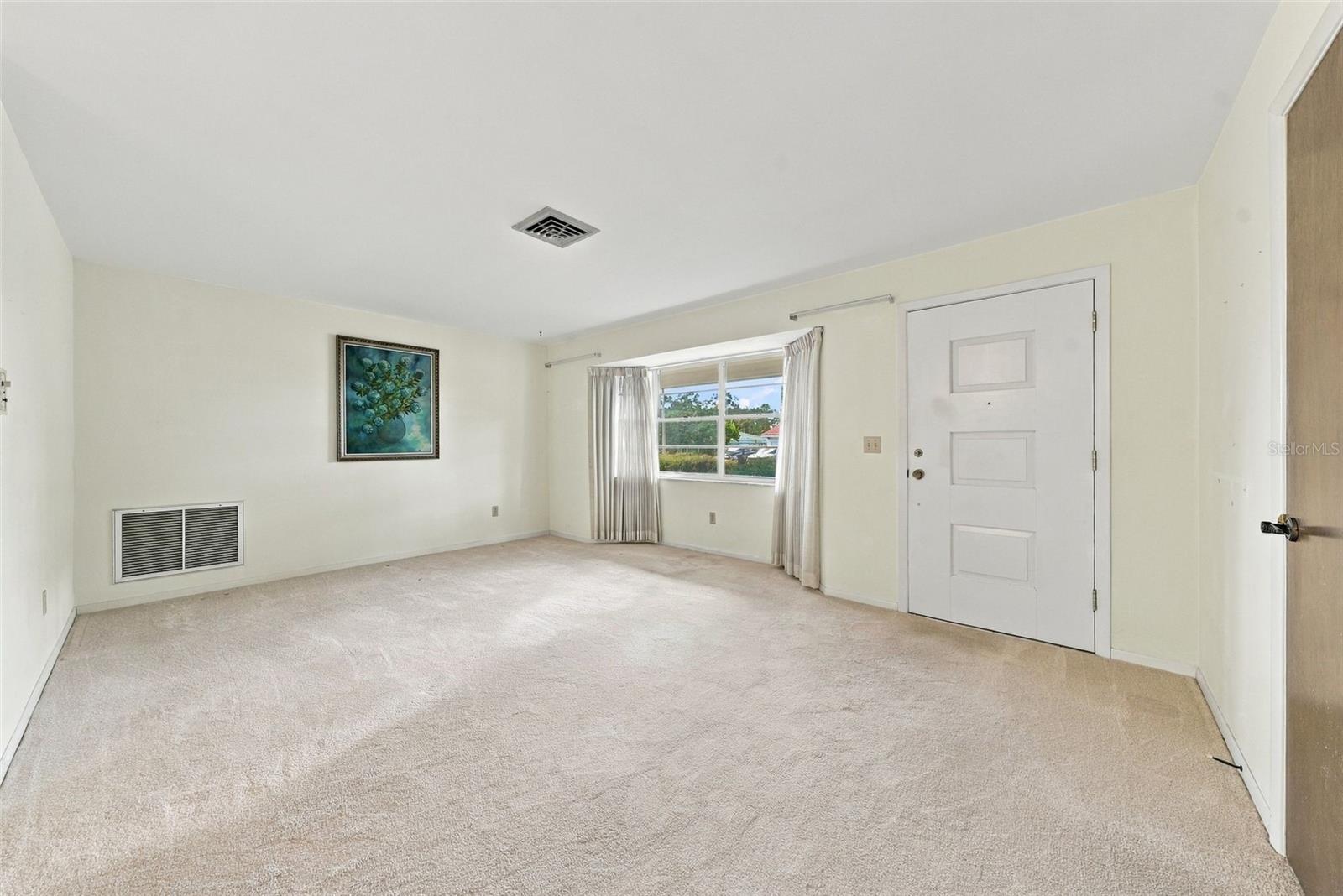 Alternate view of living area featuring large windows Alternate view of living area featuring large windows