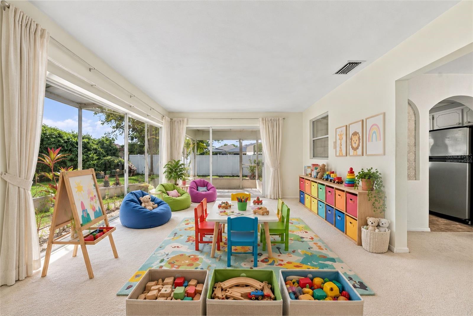 Virtually Staged, can be turned into a playroom with lots of natural light from the sliding glass doors showcasing versatile space