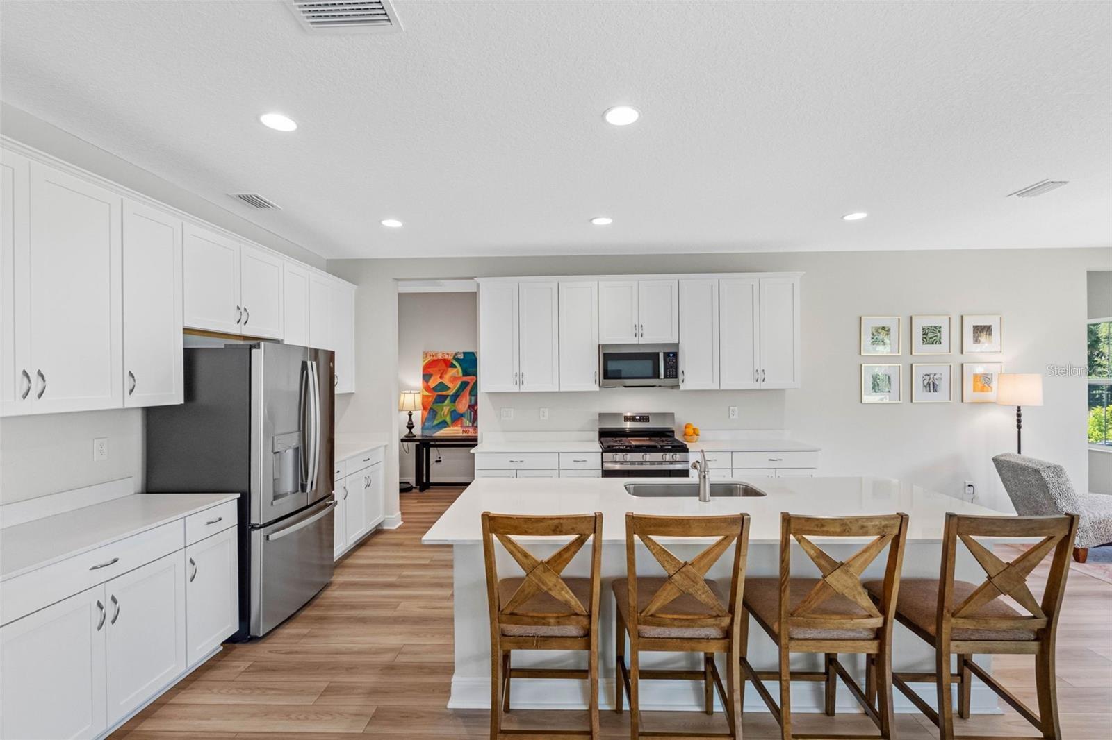 Kitchen with quartz countertops, a seating island, and a gas range Kitchen with quartz countertops, a seating island, and a gas range