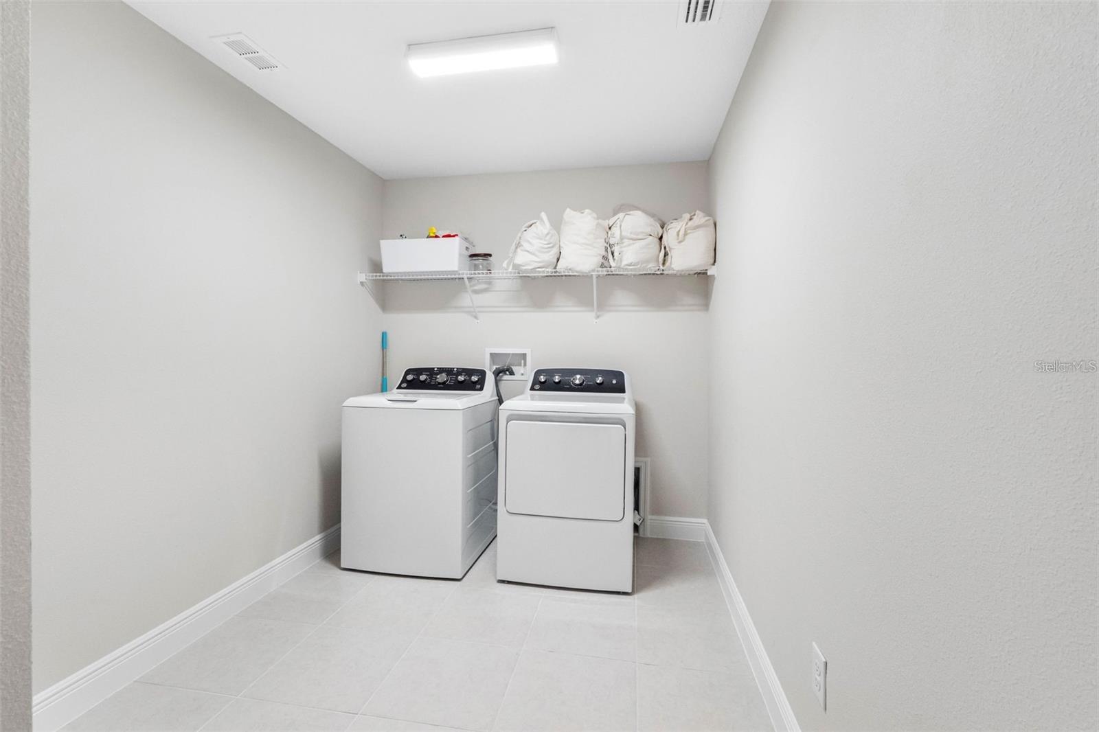Upstairs laundry room with tile floors