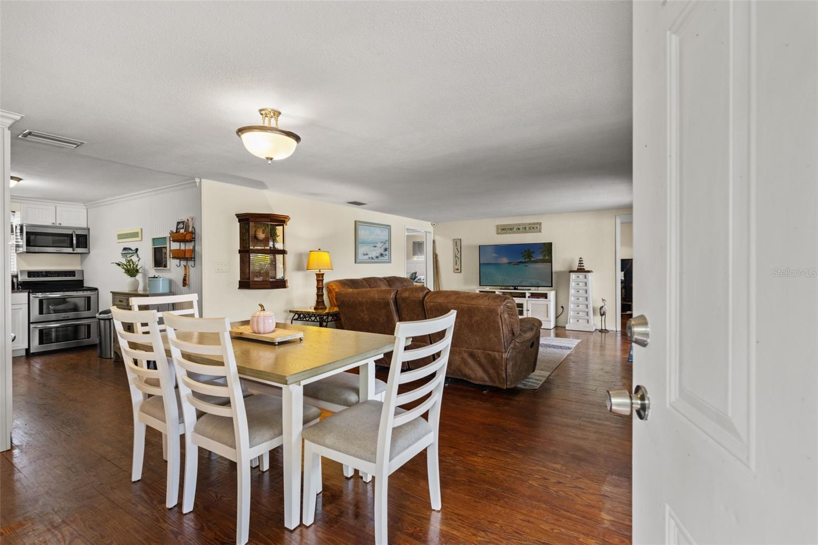 Welcome inside! Warm wood flooring extends throughout the open living and dining areas, creating an inviting space that flows naturally into the kitchen. The layout offers flexibility for everyday living and entertaining.
