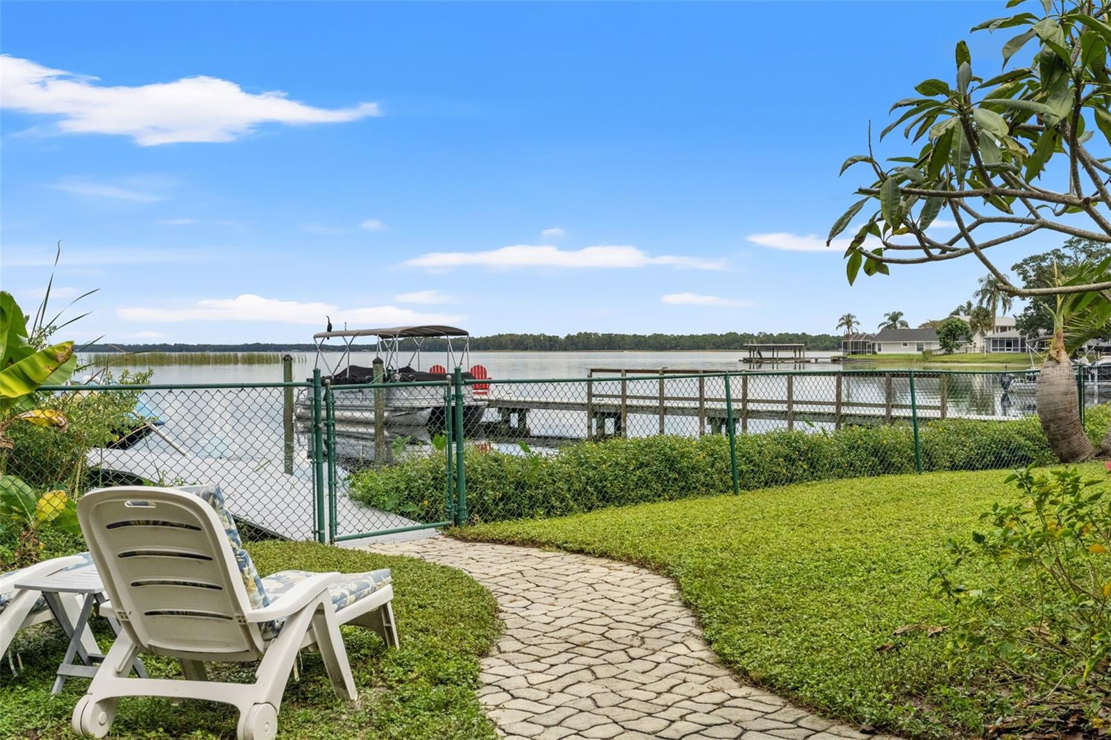 Imagine starting your morning with coffee overlooking the water or spending a quiet afternoon watching boats pass by. This backyard seating area offers beautiful lake views, with a private dock and convenient waterfront access just beyond the gate.
