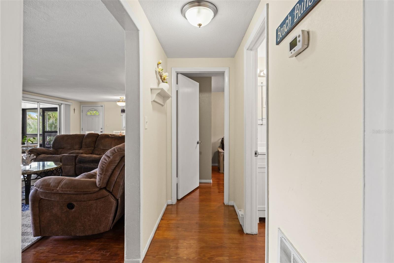 Wood flooring continues through the hallway, connecting the bedrooms and bathroom to the main living area. The convenient layout keeps everything within easy reach on the upper level.