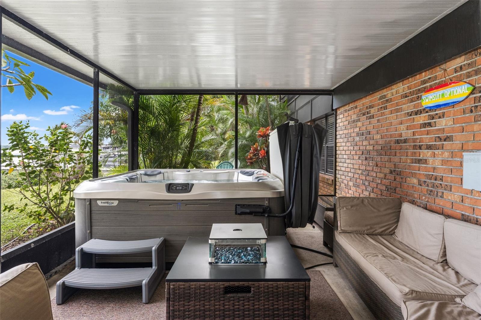 Relax in the hot tub while enjoying the privacy of the screened enclosure and surrounding tropical greenery. With comfortable seating nearby, this covered outdoor space offers a wonderful setting for year-round Florida relaxation.