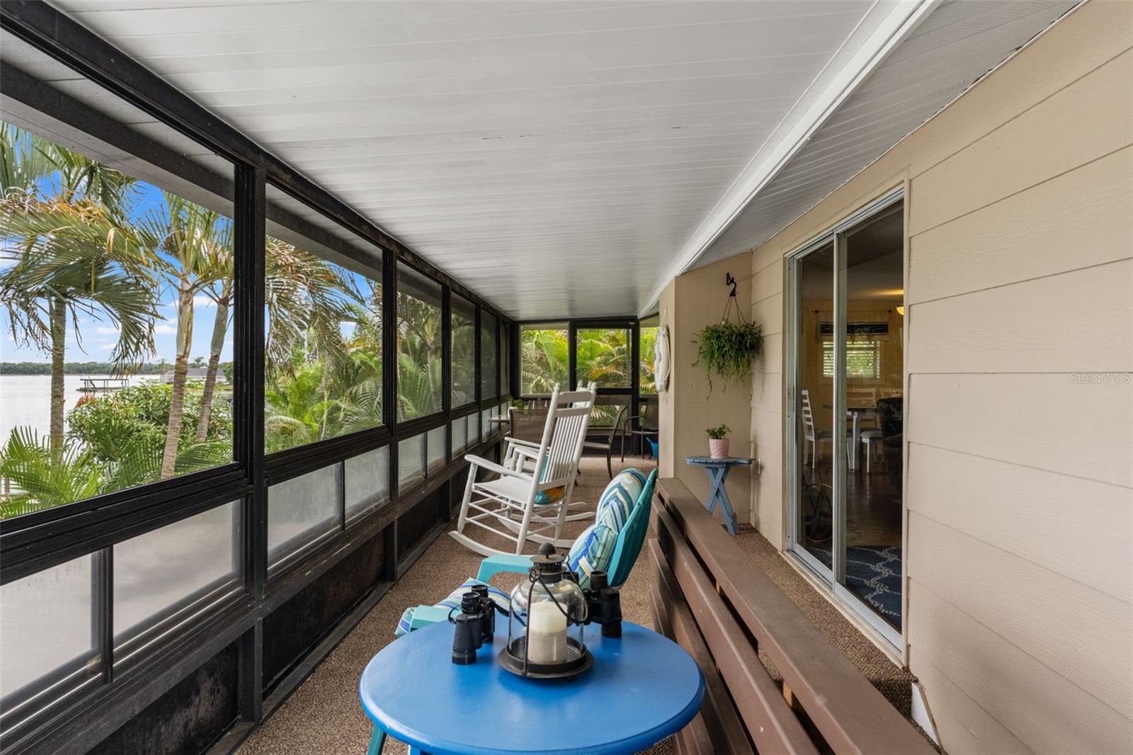 Imagine starting your mornings here! This long, screened porch overlooks the water and surrounding palms, with plenty of room for rocking chairs, conversation, and quiet relaxation. Sliding glass doors provide convenient access to the main living area.