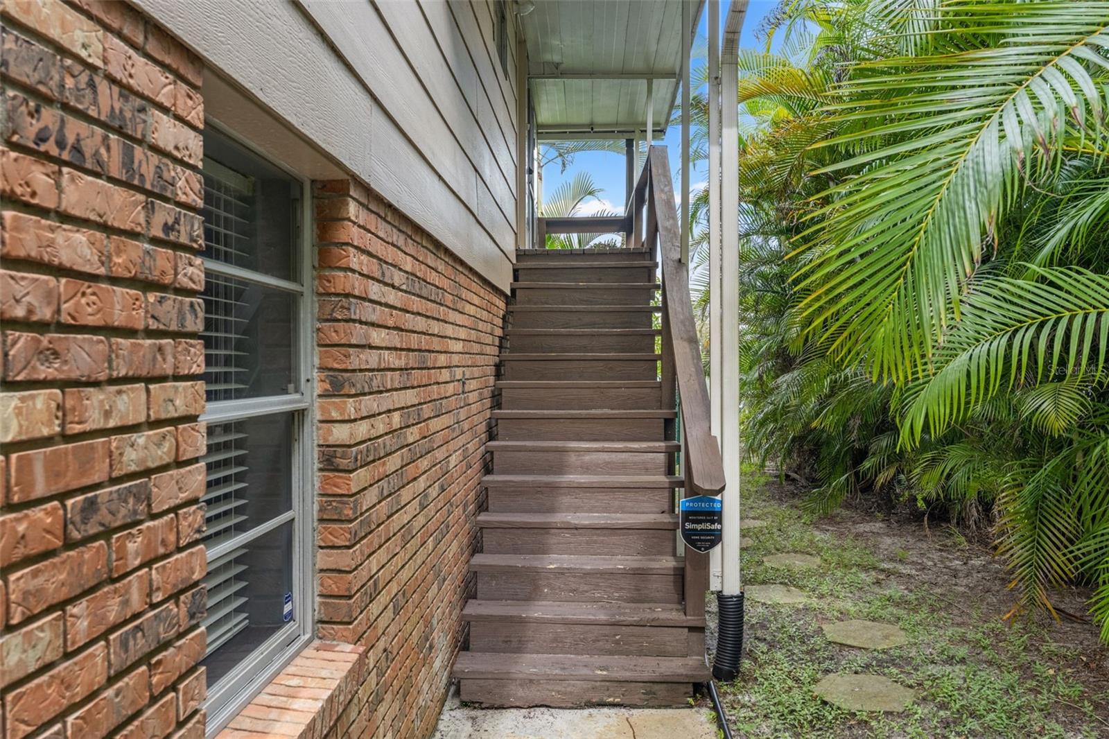 A private exterior staircase leads to the upper-level entrance, providing convenient access to the main living area while preserving the home's distinctive elevated design.