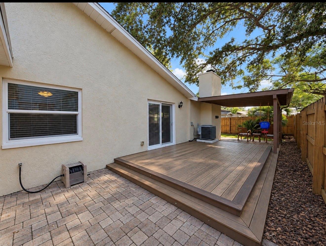 paver side of home with entertainment deck