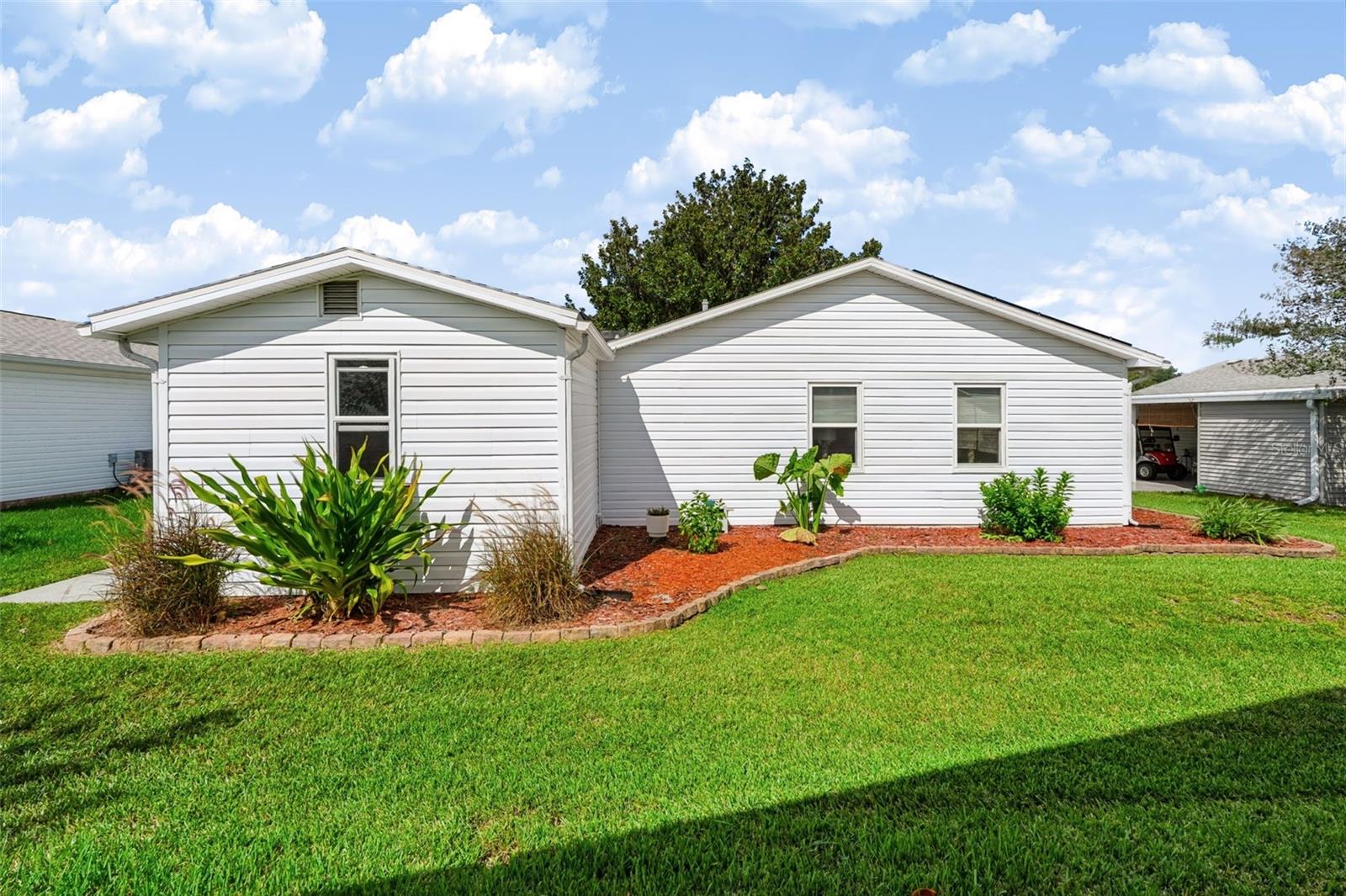 Backside of home with landscaping