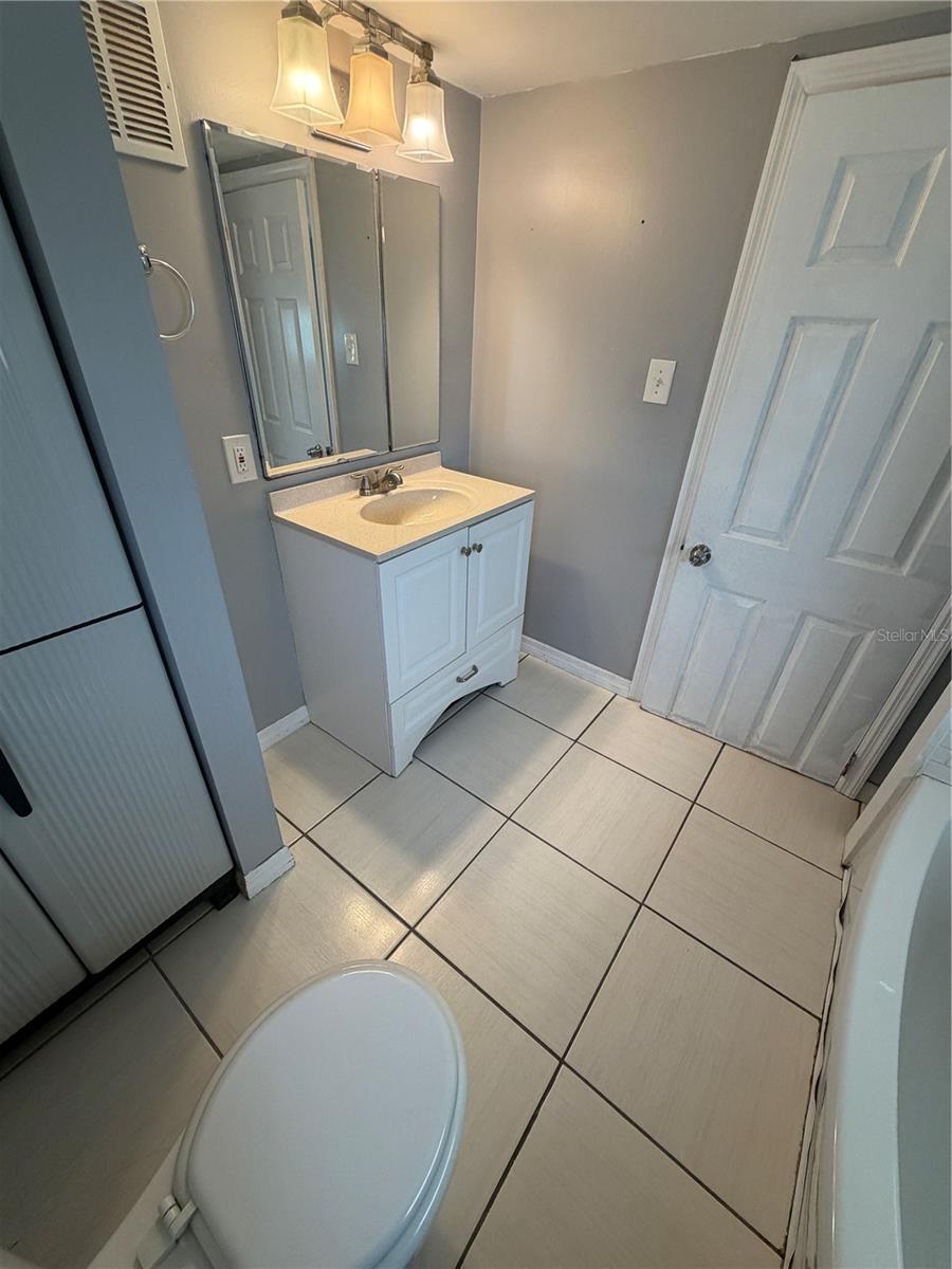 Bathroom with sink, tub/shower combo and toilet.