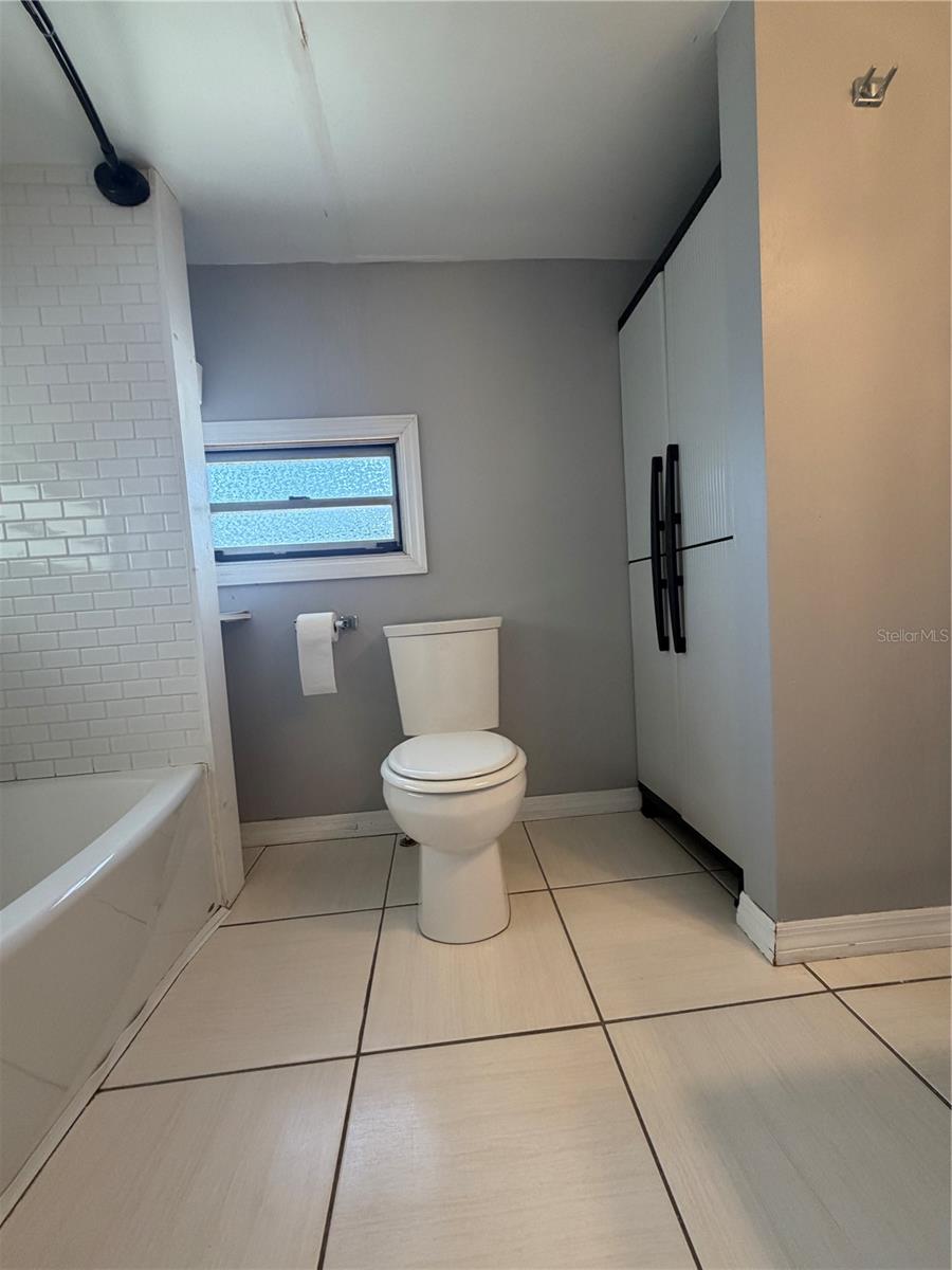 Bathroom with view of storage, tub/shower.