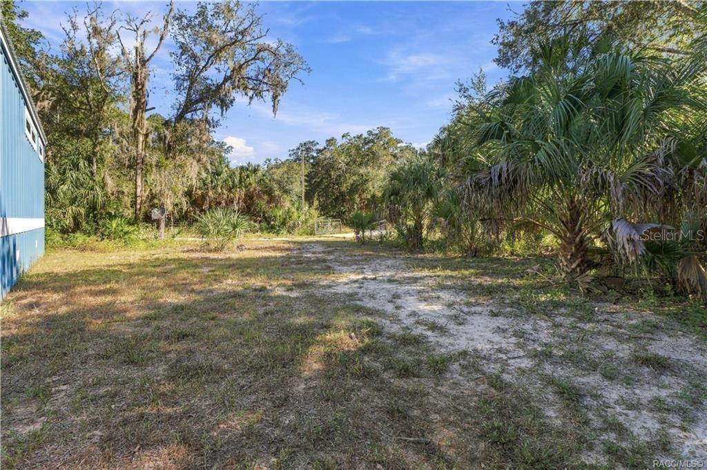 BRING YOUR TOYS & ENJOY THE SPACE! The 1.42-ACRE FULLY FENCED PROPERTY offers open areas, mature trees, Florida palms & a gated entrance.