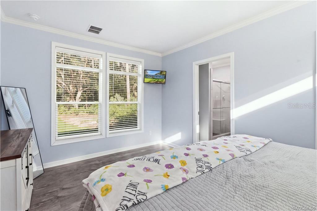 BRIGHT & RELAXING PRIMARY SUITE! Large windows overlook the natural surroundings, while the adjoining PRIVATE BATH offers a convenient WALK-IN SHOWER.