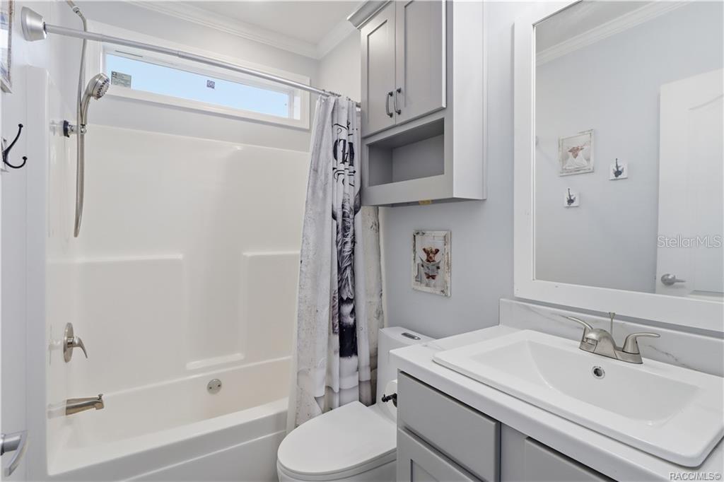 STYLE & EVERYDAY CONVENIENCE! The SECOND FULL BATHROOM features a GRAY VANITY, framed mirror, additional wall cabinetry & a TUB/SHOWER COMBINATION.