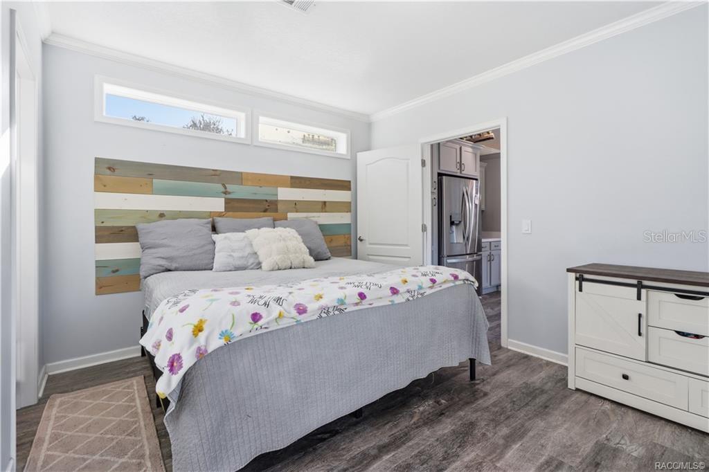 YOUR OWN COMFORTABLE RETREAT! The PRIMARY BEDROOM features beautiful natural light, neutral finishes, LUXURY VINYL PLANK FLOORING & a distinctive wood-accent headboard.