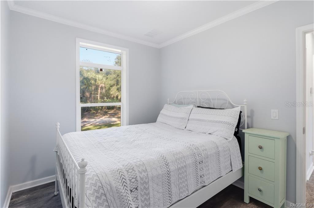 A PEACEFUL PLACE TO UNWIND! This inviting BEDROOM features soft neutral colors, attractive flooring, crown molding & a large window overlooking the beautiful natural surroundings.