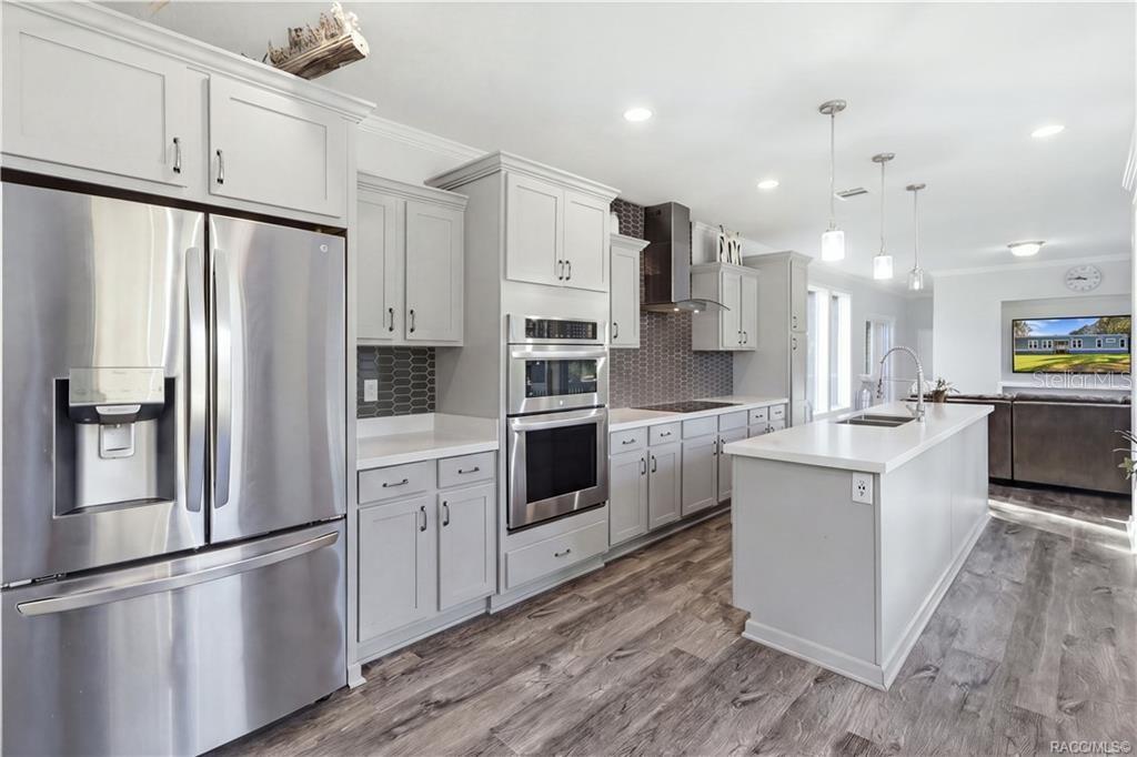 STYLE MEETS FUNCTION! The thoughtfully designed kitchen features GRAY CABINETRY, a DOUBLE-BASIN SINK, sleek spring-style faucet & large windows overlooking the beautiful outdoors.