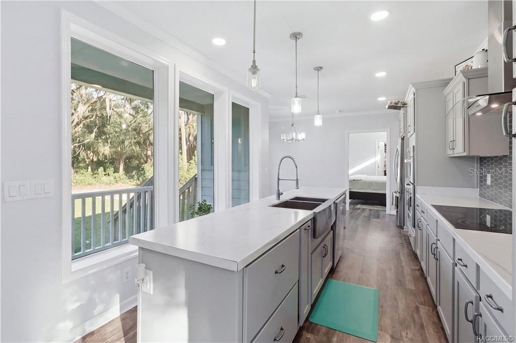 A KITCHEN W/A VIEW! The impressive island offers generous workspace, while large windows bring in natural light & showcase the surrounding greenery.