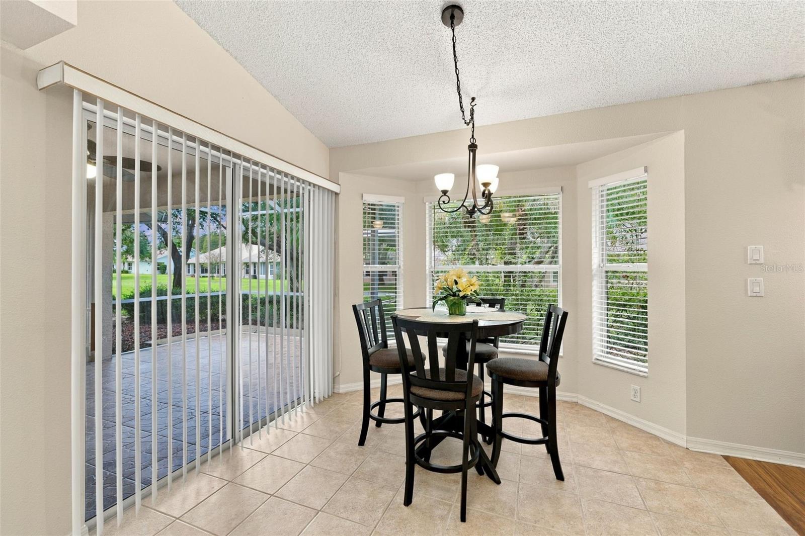 Eat in nook with bay window and a sliding door out to the screened-in lanai