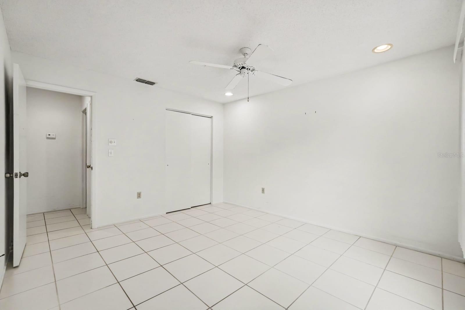 Generously Sized Bedroom with Ceiling Fan and Wall-to-Wall Tile Flooring