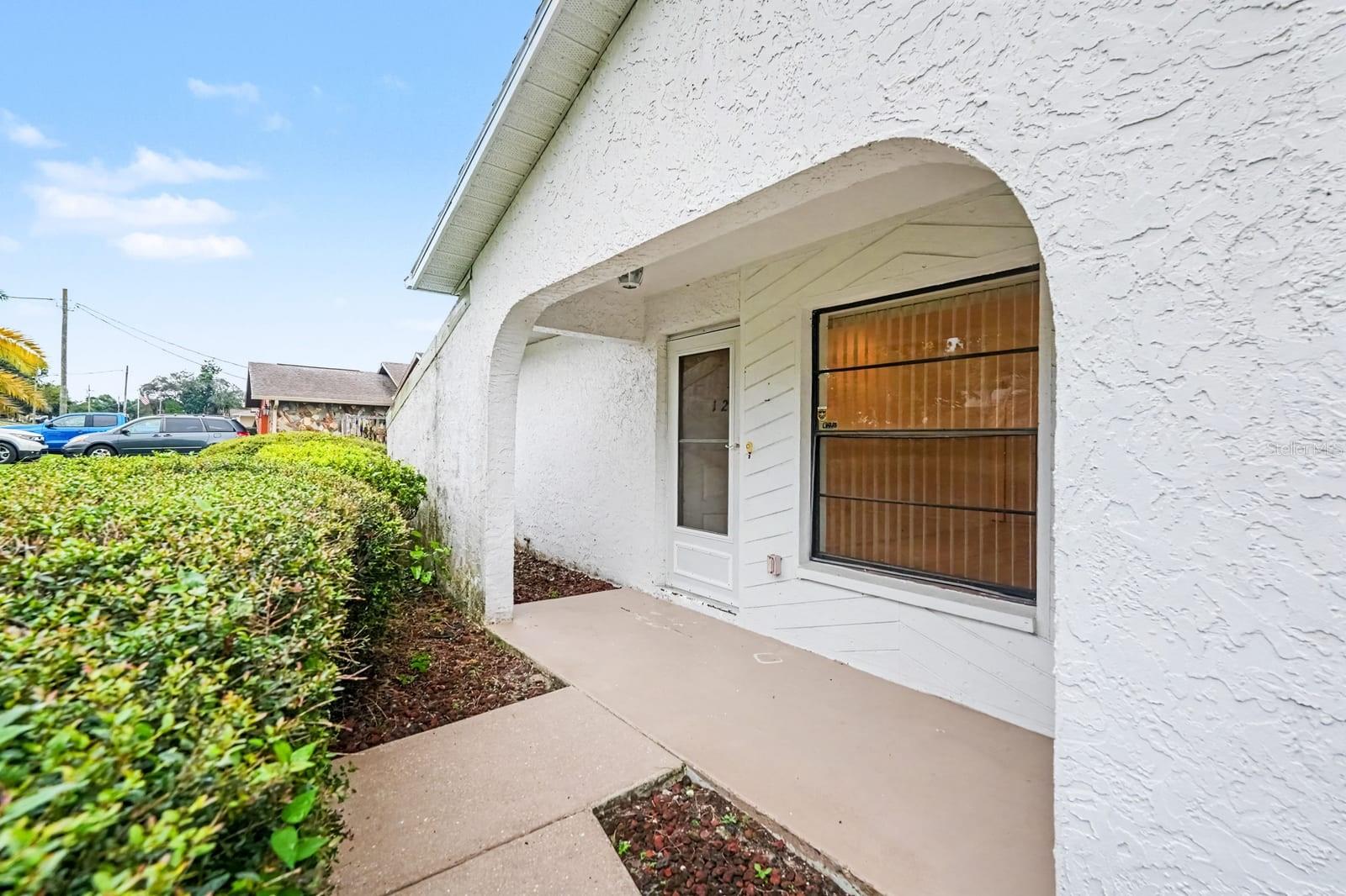 Covered Entryway with Arched Design and Wood-Look Garage Door