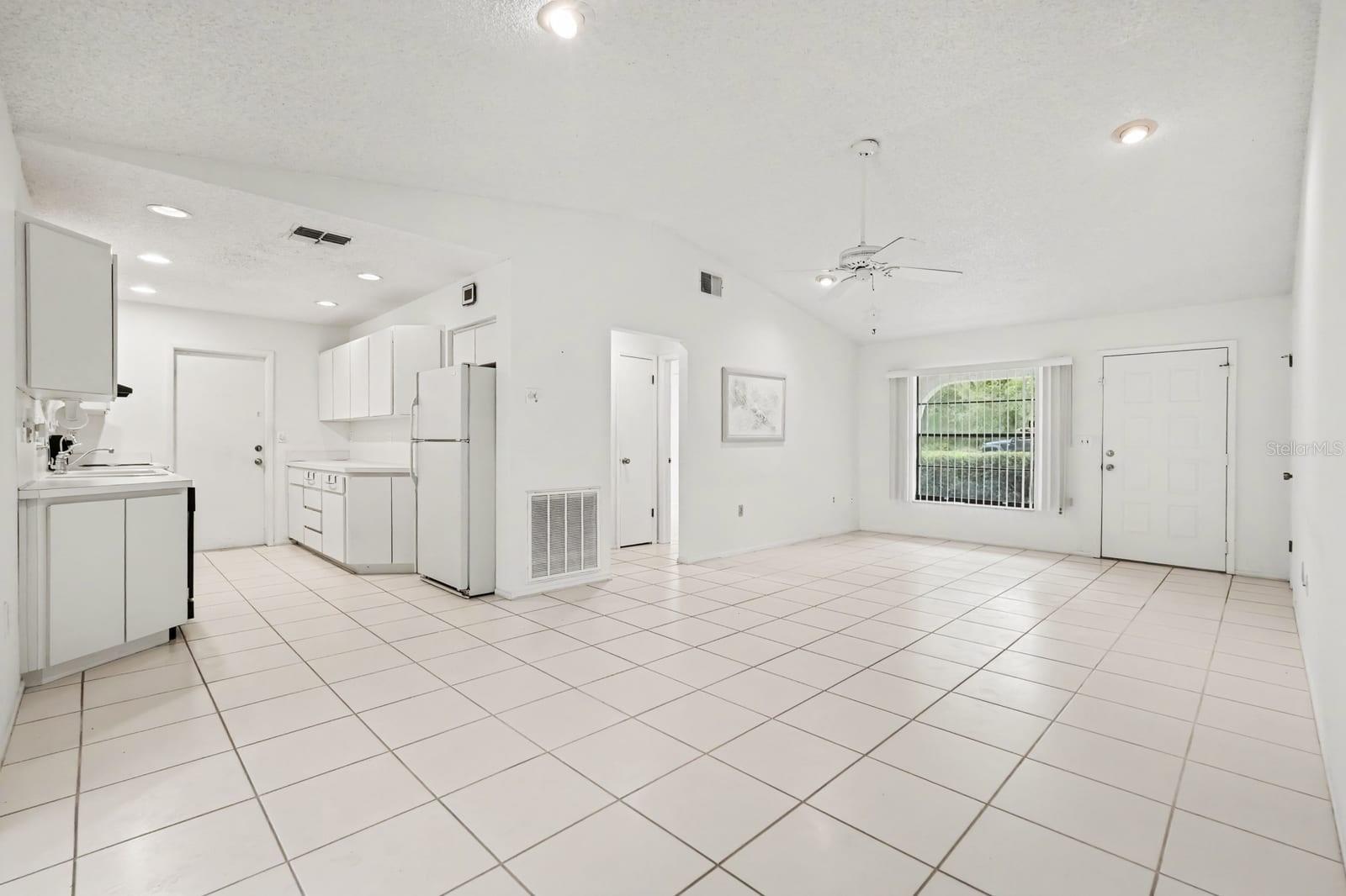 Open Concept Kitchen and Living Area with Tile Flooring and Sliding Doors