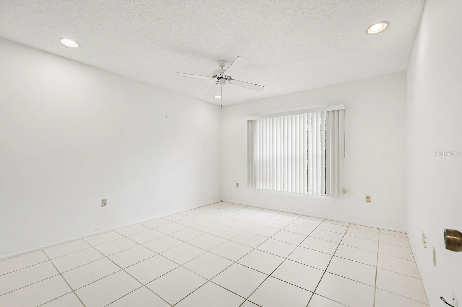 Bright Bedroom with Large Window, Ceiling Fan & Neutral Decor