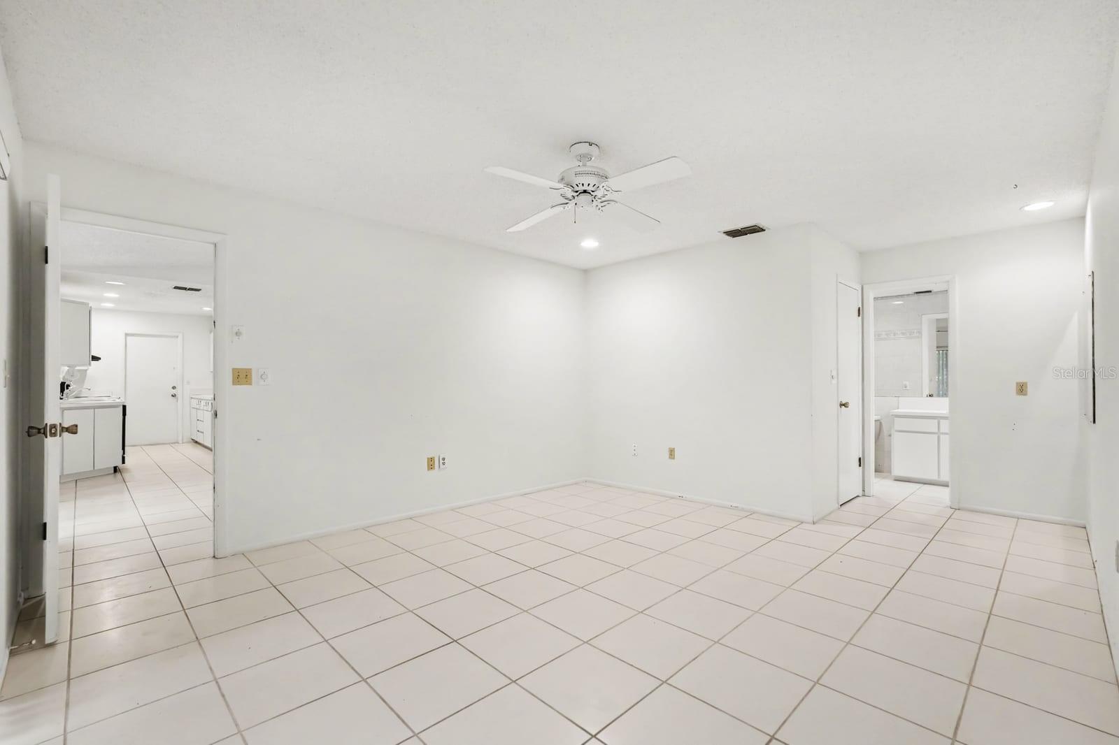 Open Living Area with Tile Floors, Ceiling Fan, and Dual Access Doors