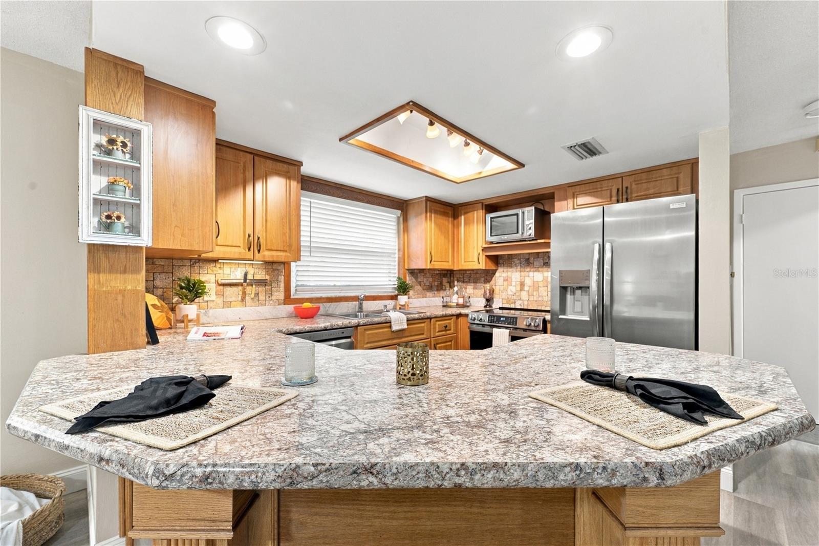 15. Updated Kitchen (9.4 x 12.2') Features a Spacious Breakfast Bar..