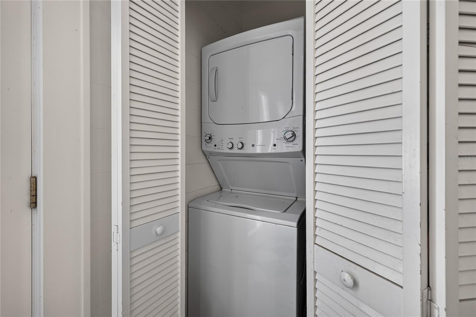 Stackable washer and dryer in laundry closet in the kitchen