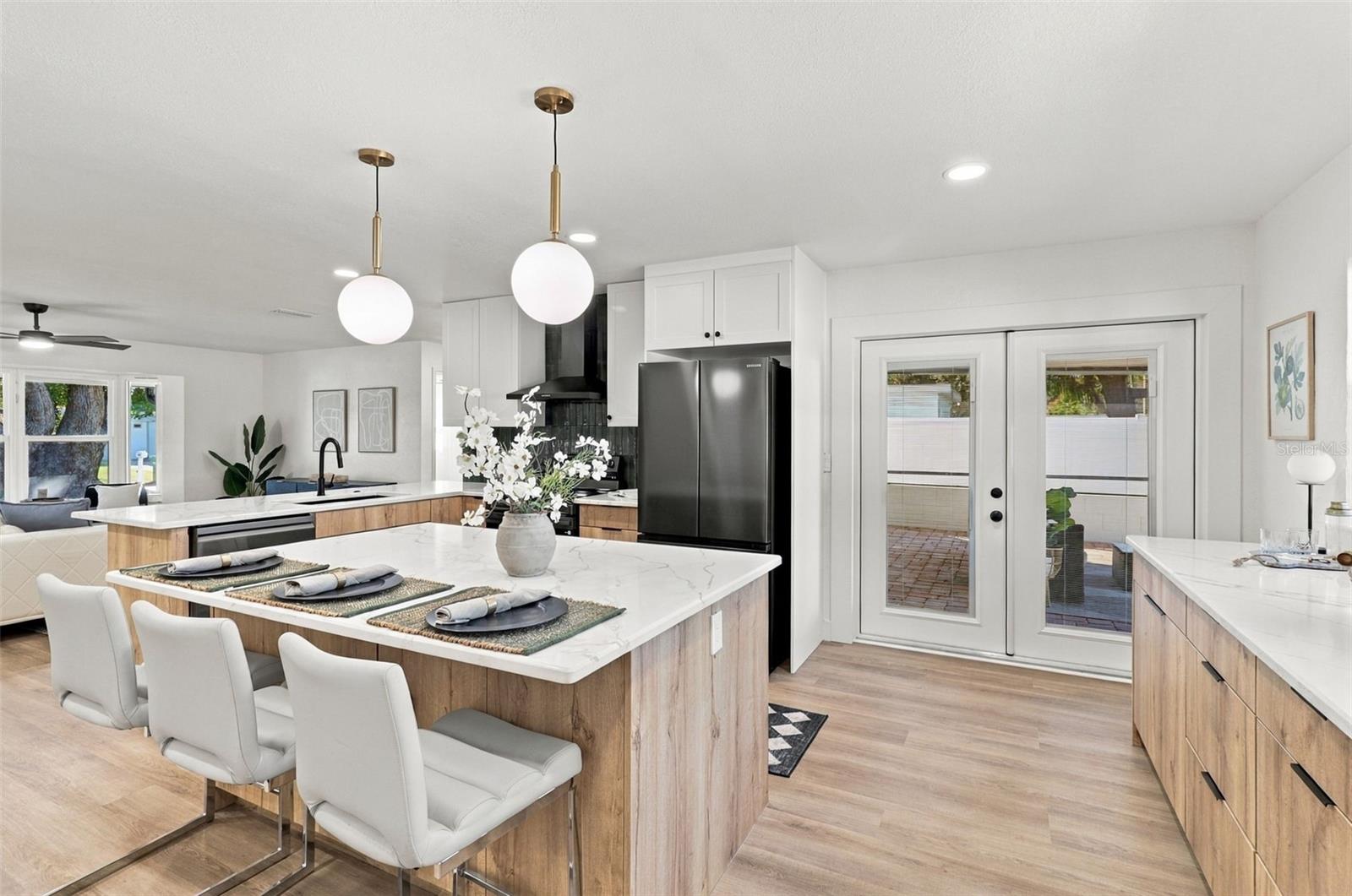 Beautifully updated kitchen featuring quartz countertops, stainless steel appliances, and French doors leading to the outdoor living area. Beautifully updated kitchen featuring quartz countertops, stainless steel appliances, and French doors leading to the outdoor living area.