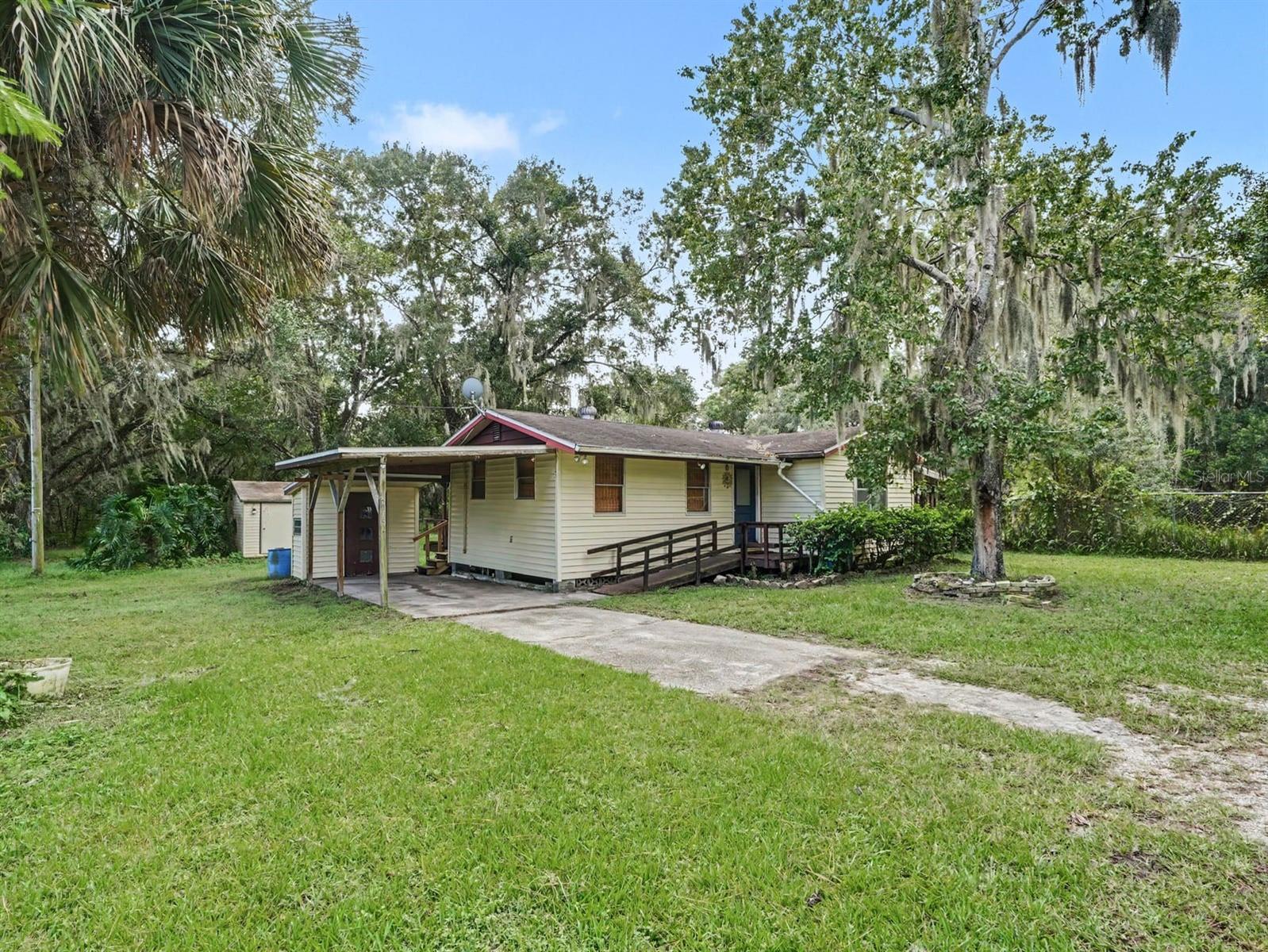 Elevated home with front porch and mature oak canopy