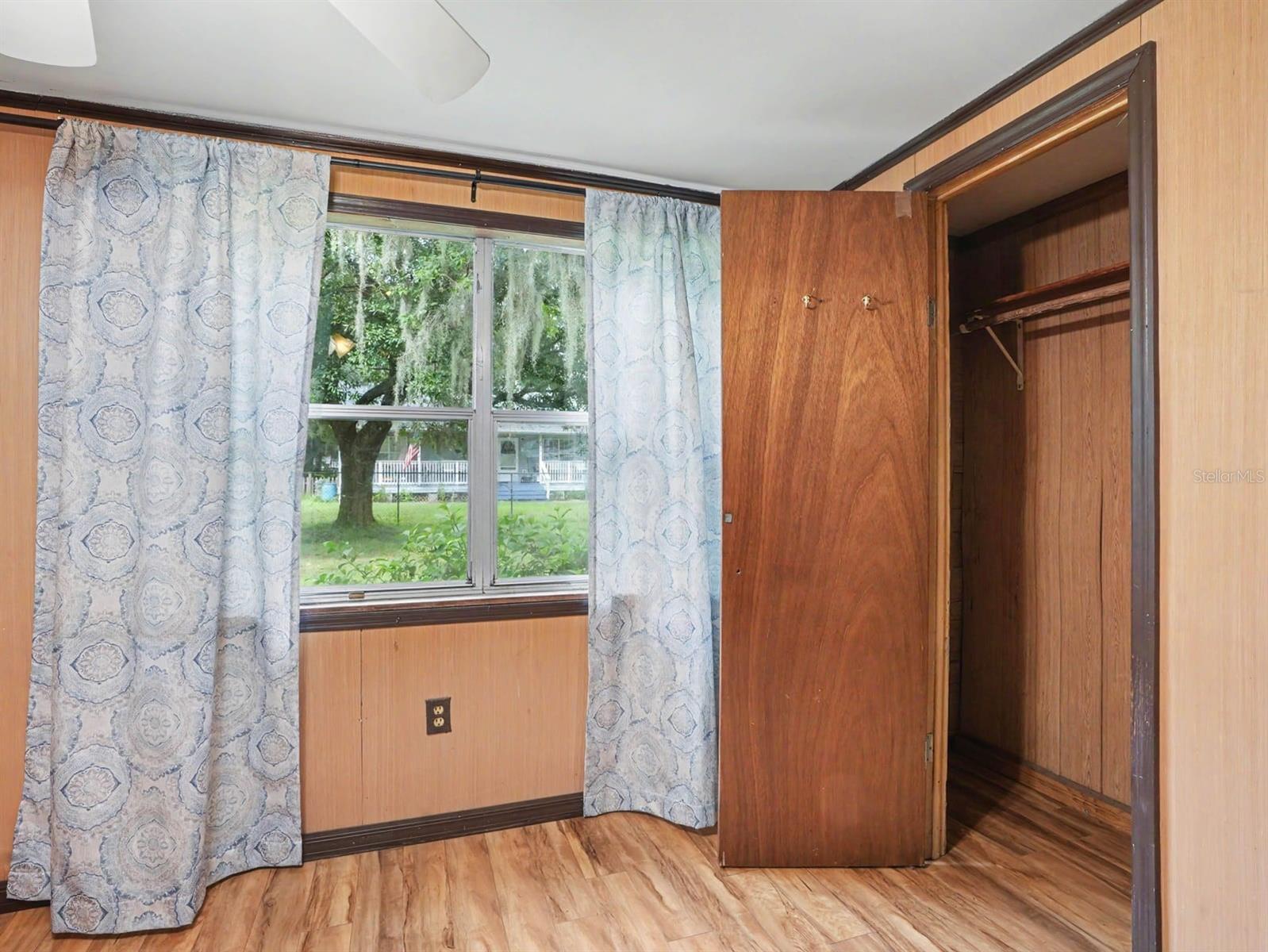 Bedroom with Wood Closet, Window Treatments & Access to Outdoor Spaces