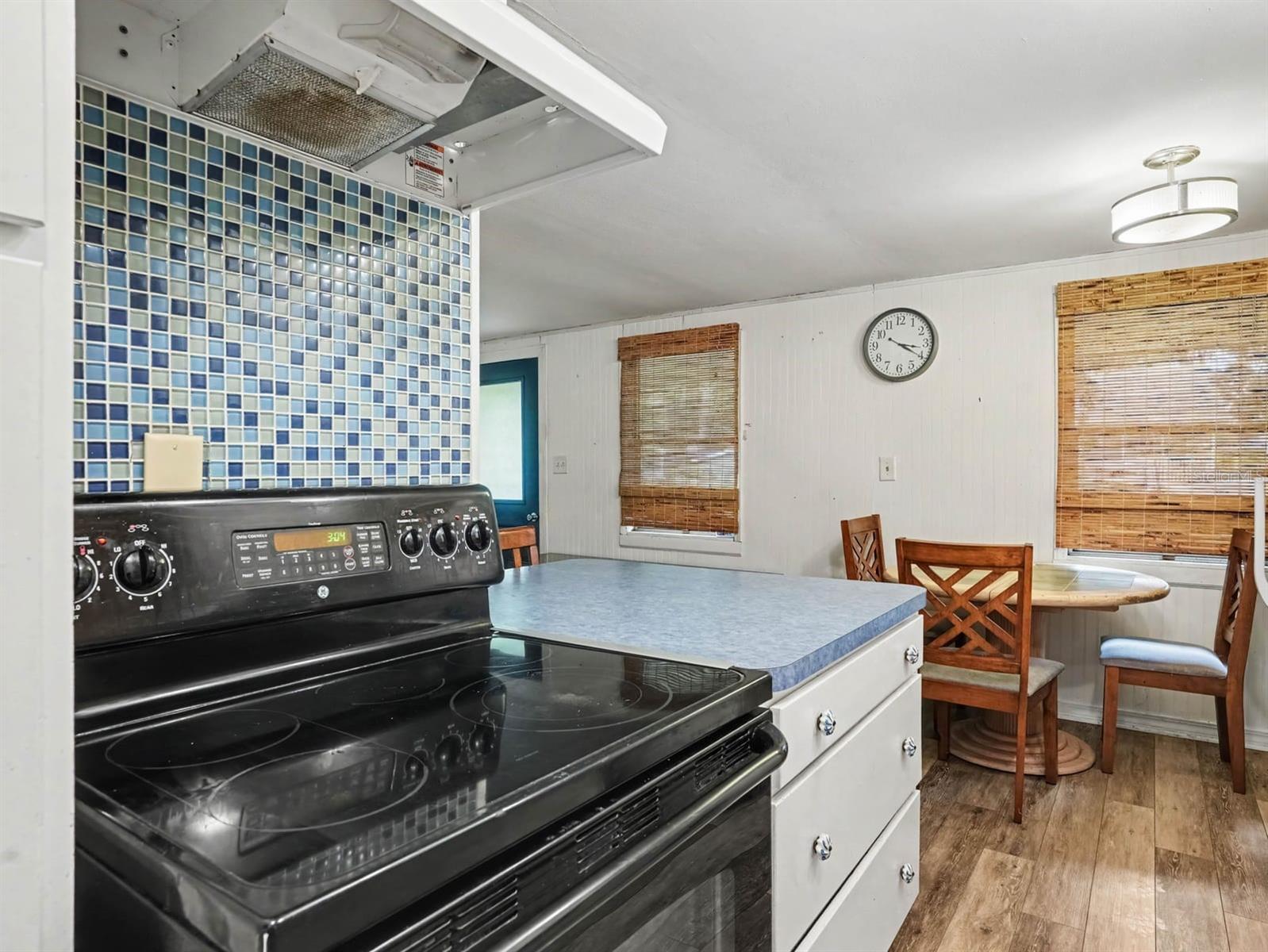 Spacious Kitchen with Double Oven, Blue Tile Accents & Breakfast Dining Area