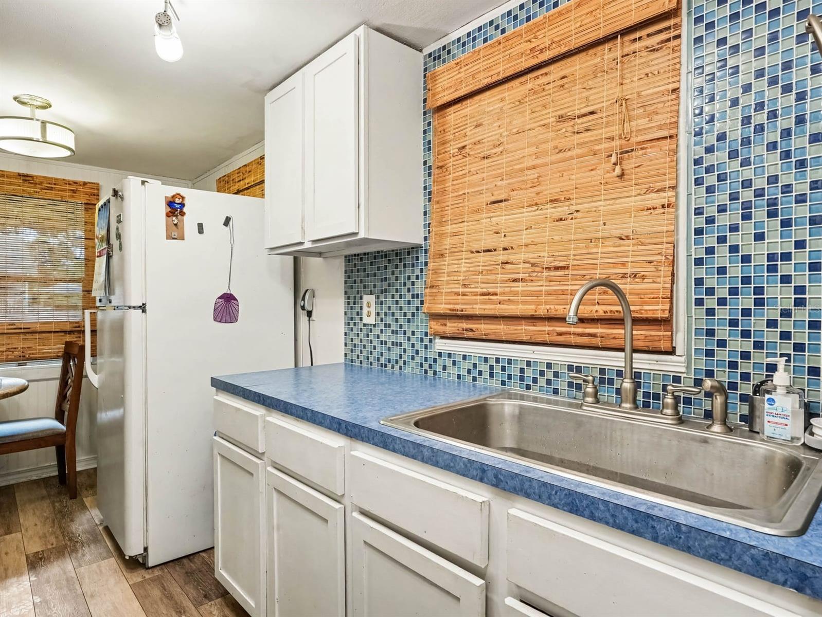 Updated Kitchen with Blue Tile Backsplash, Stainless Steel Sink & Modern Appliances
