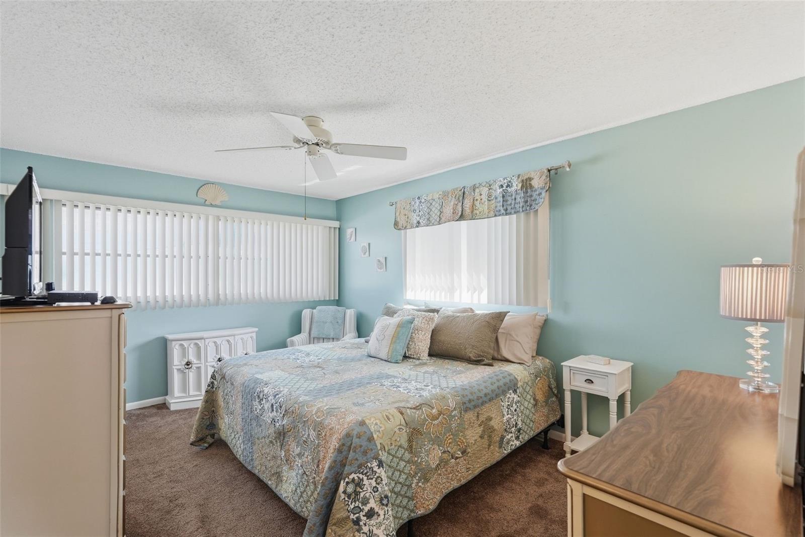 Primary bedroom with ceiling fan, natural light, and room for furnishings. Primary bedroom with ceiling fan, natural light, and room for furnishings.