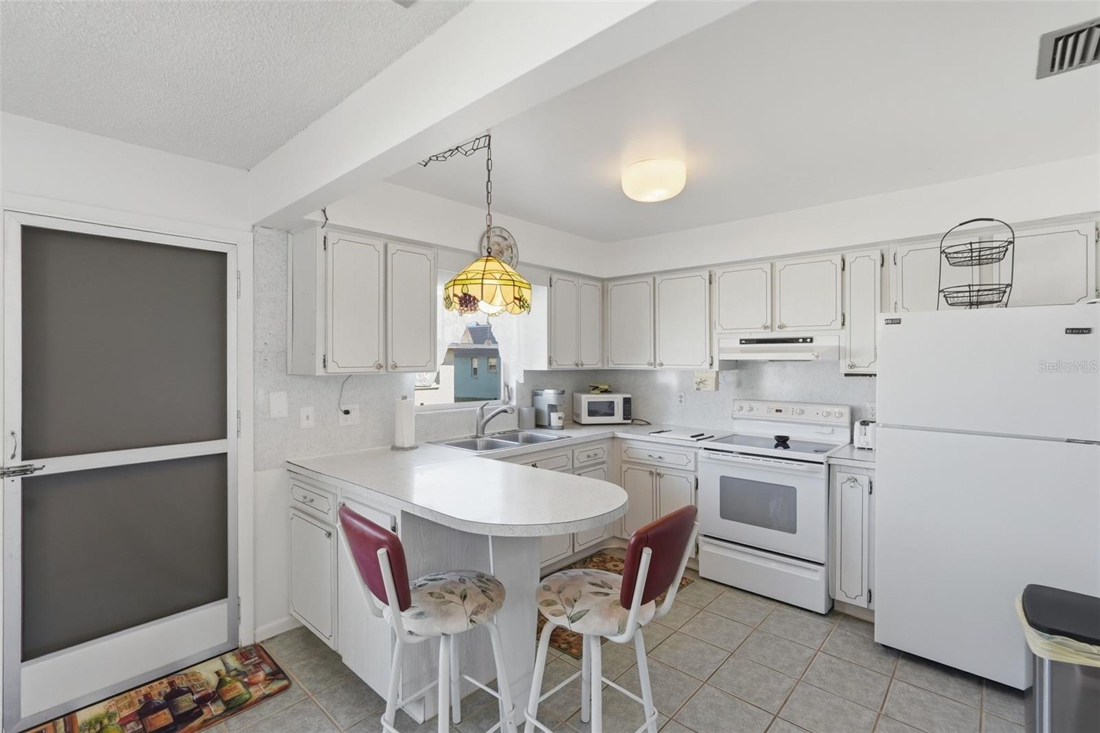 Additional kitchen view highlighting cabinet storage and casual dining.