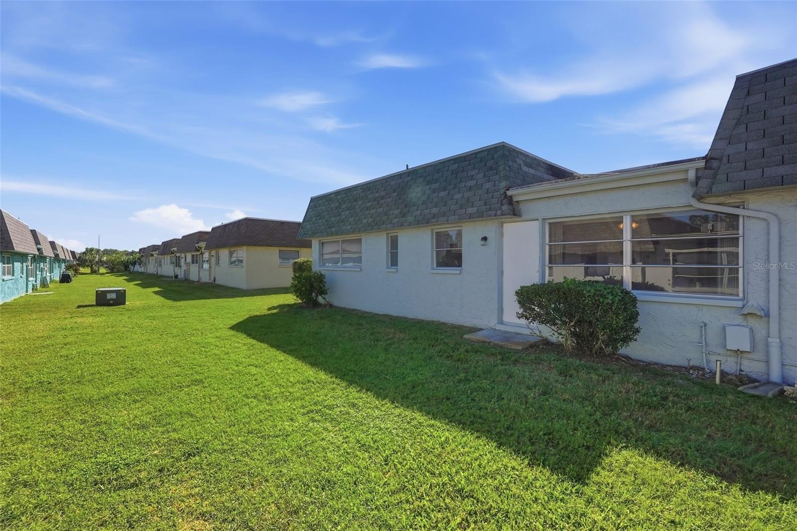 Additional exterior view with green space surrounding the residence.