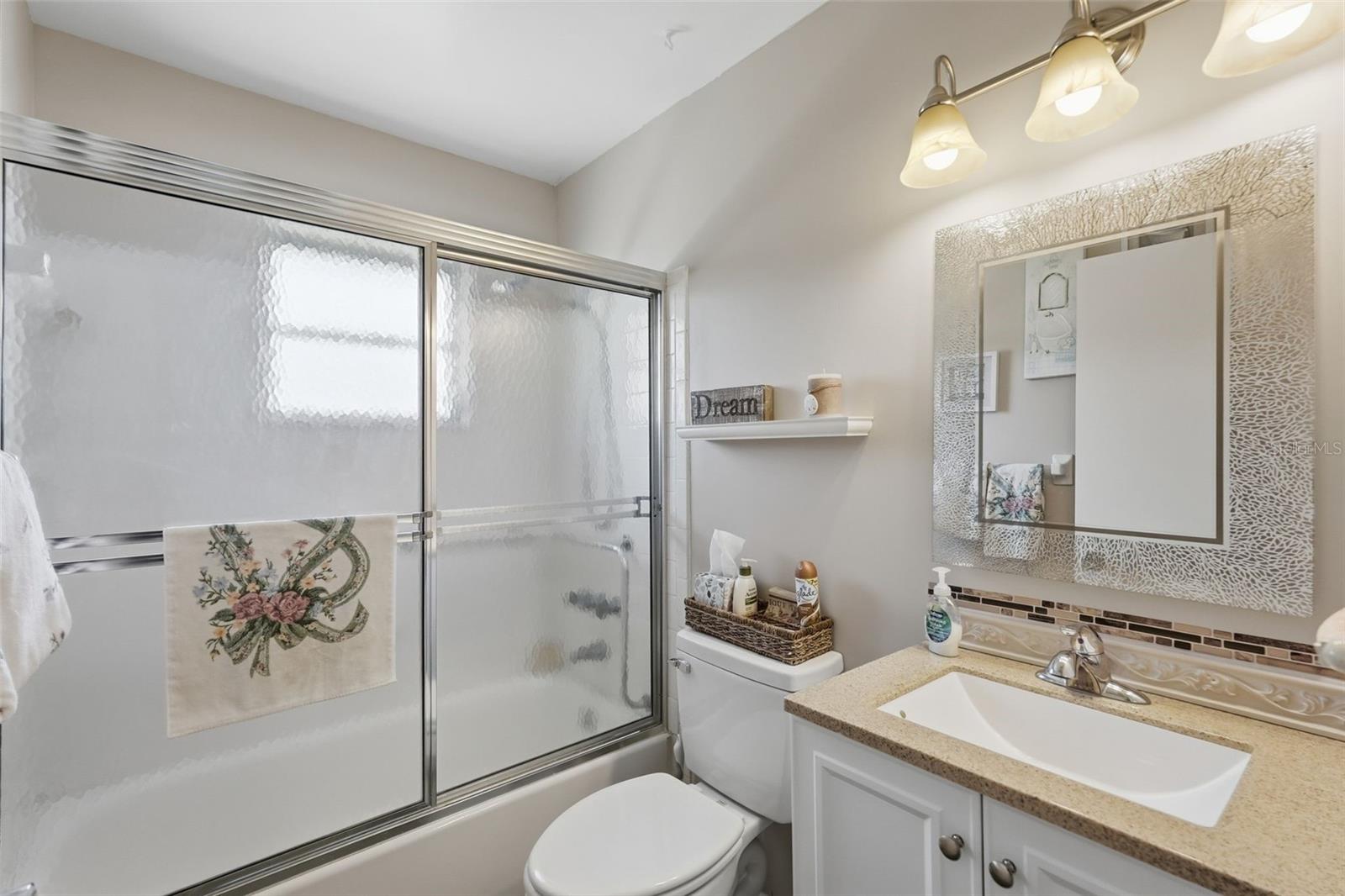 Bathroom 2 features a single-sink vanity and glass-enclosed shower. Bathroom 2 features a single-sink vanity and glass-enclosed shower.