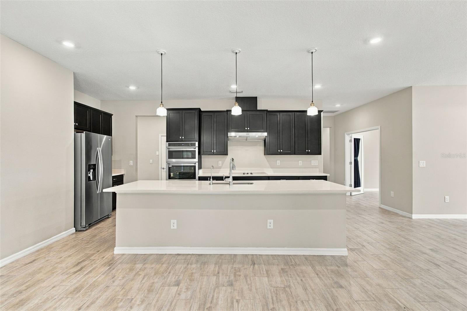 Kitchen viewed from Living Room - mudroom & door to garage on the left, office entry on the right