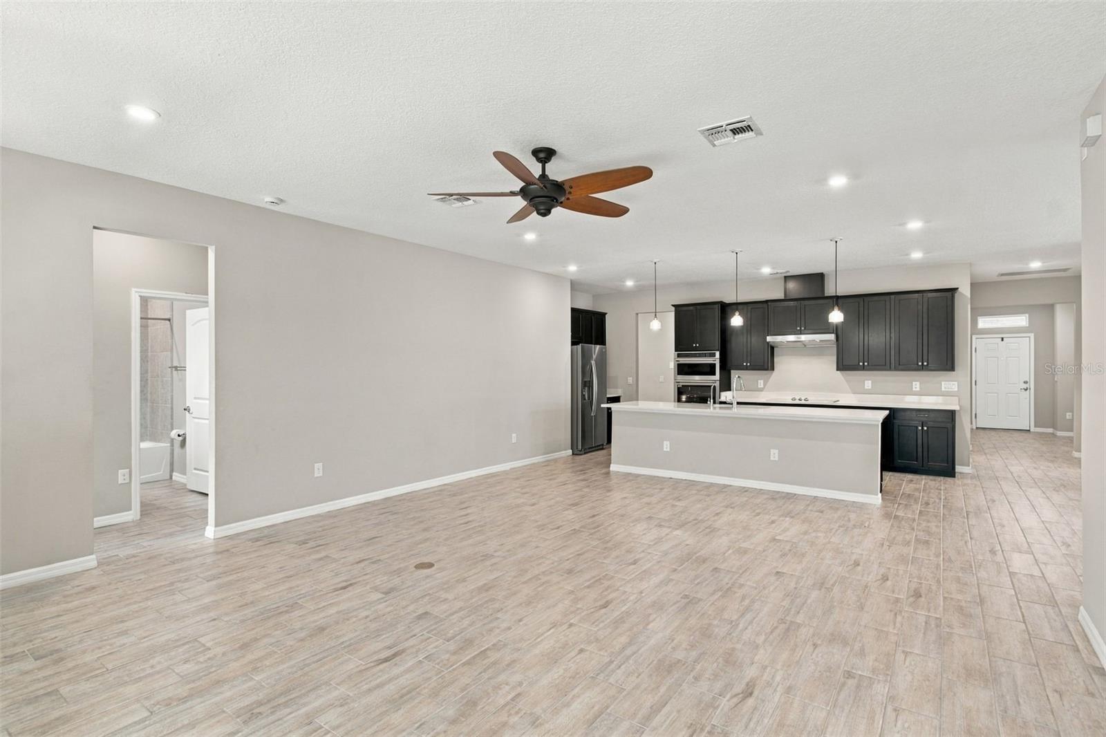 Living Room with ceiling fan, Kitchen in background