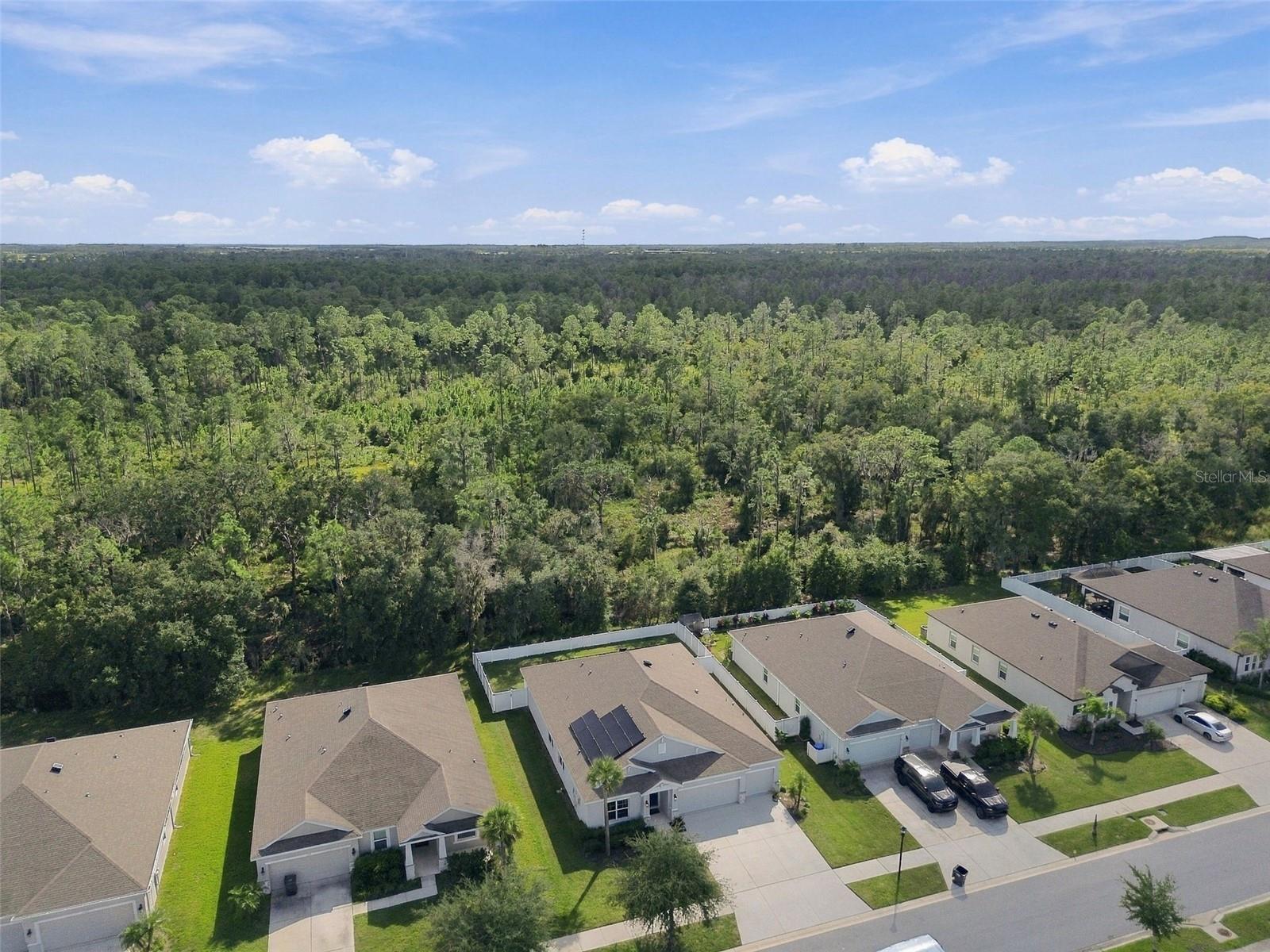 Drone view of property and expansive conservation