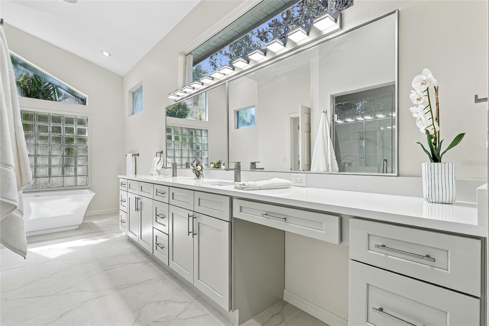 Modern and sleek primary bathroom vanity with make up area.